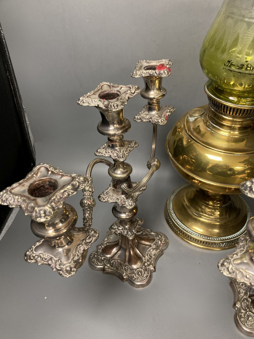 A pair of plated two branch candelabra and a brass oil lamp (3)